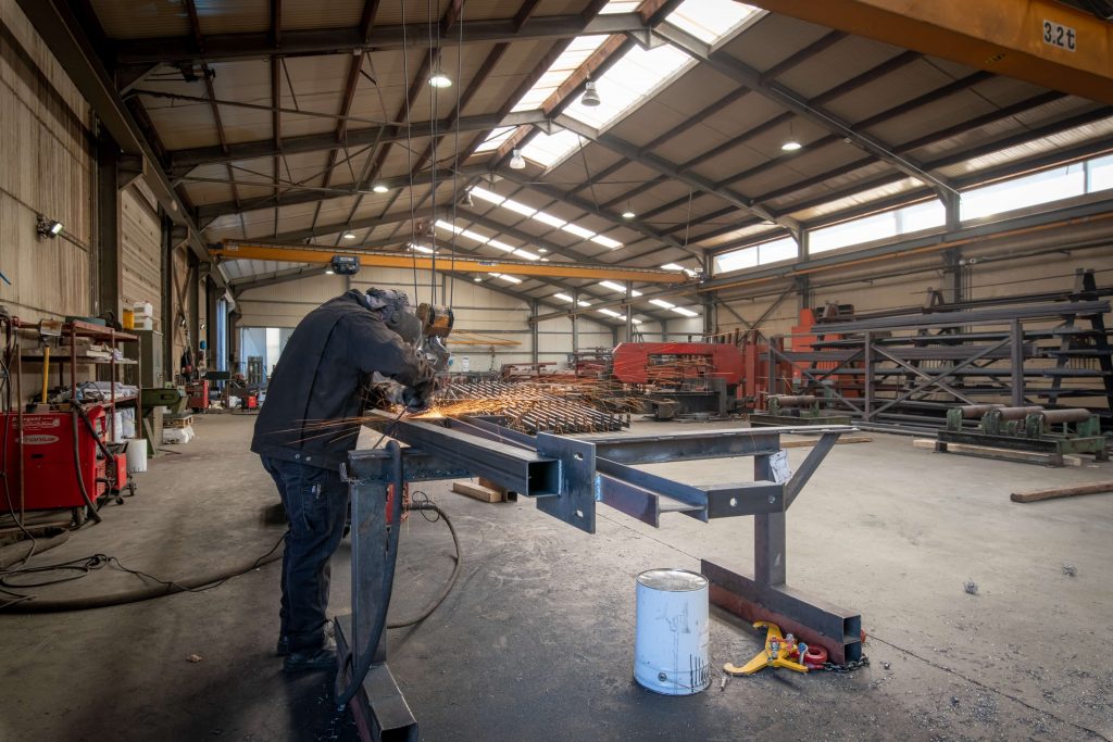 Équipe Metalux Designs - Professionnel travaillant sur une structure métallique